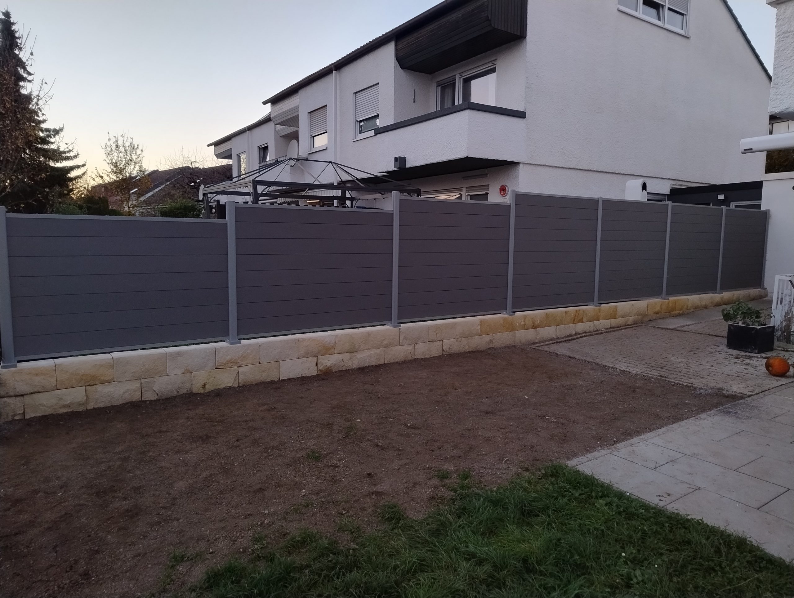 Moderner Sichtschutzzaun mit Stützmauer